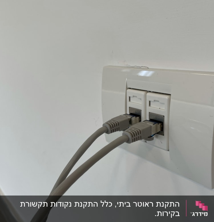 שני כבלי רשת מחוברים לשקע קיר לבן